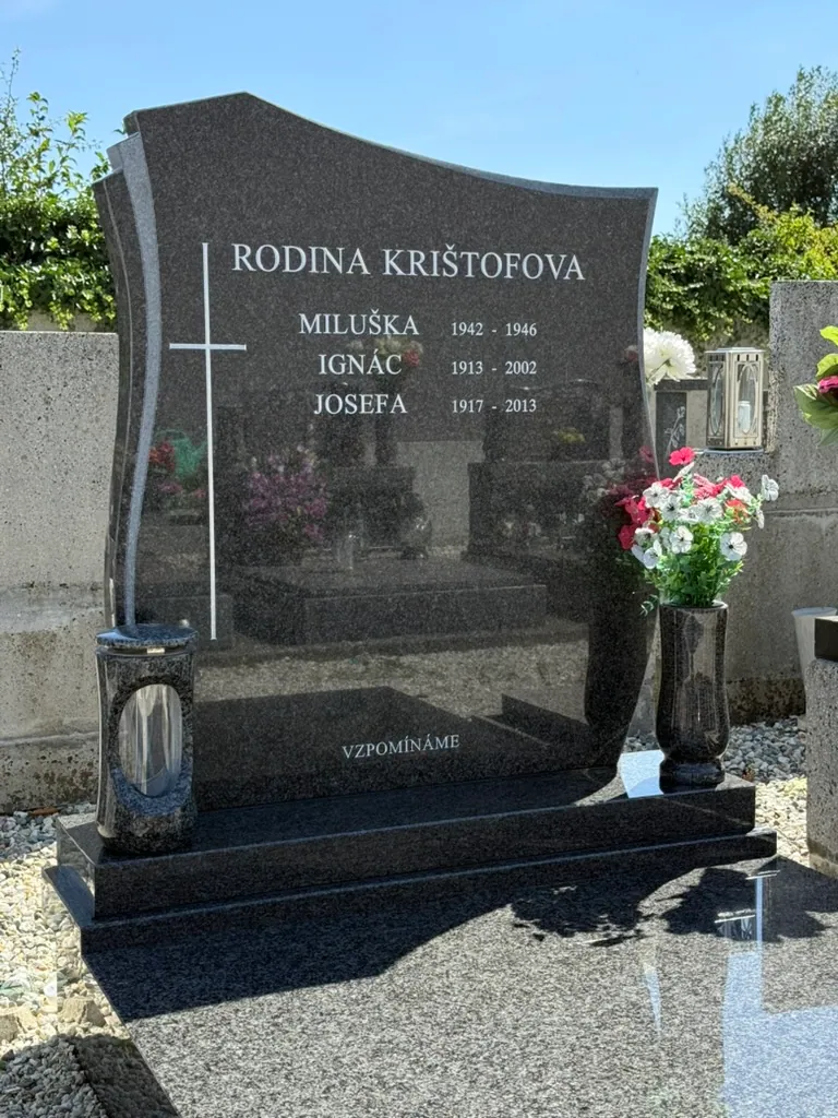 Tmavý leštěný pomník s tvarovanou nápisovou deskou, světlým křížem, vázou a lucernou — STONIA